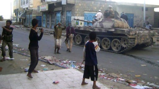 Yemeni armed tribesmen ride a tank in the southern town of Loder on Saturday. At least 222 people including 183 militants have been killed in five days of clashes around the strategic south Yemen town of Loder which Al-Qaeda is trying to seize, a security official says