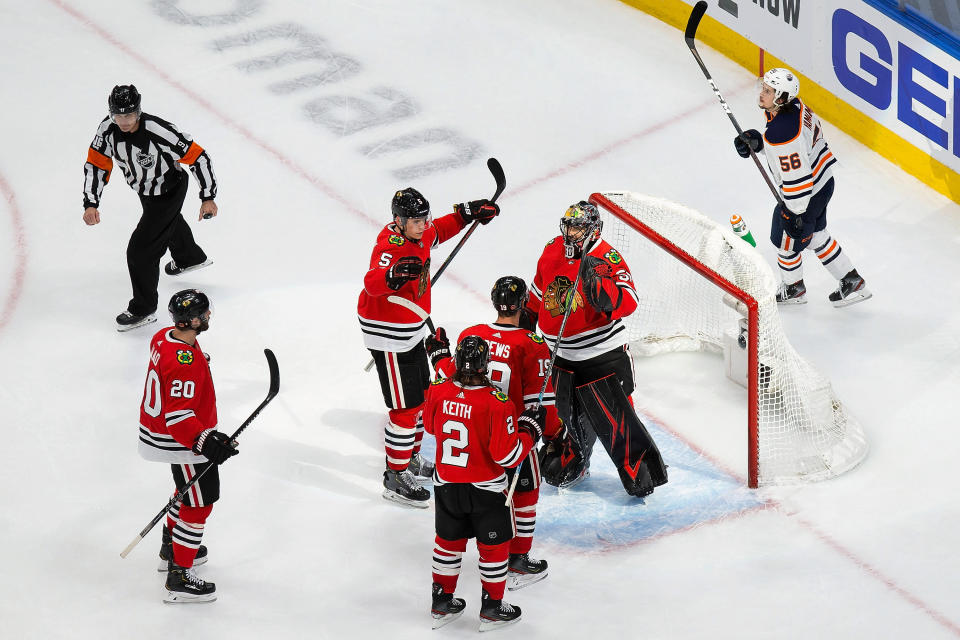 Chicago Blackhawks' Brandon Saad (20), Duncan Keith (2), Connor Murphy (5), Jonathan Toews (19) and goaltender Corey Crawford (50) celebrate the team's win over the Edmonton Oilers in an NHL hockey playoff game Wednesday, Aug. 5, 2020, in Edmonton, Alberta. (Codie McLachlan/The Canadian Press via AP)