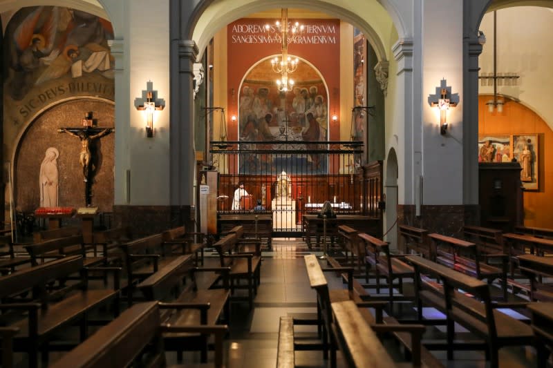 A priest serves a mass inside a chapel of an almost empty church in the Raval neighbourhood, as the coronavirus disease (COVID-19) outbreak continues, in Barcelona