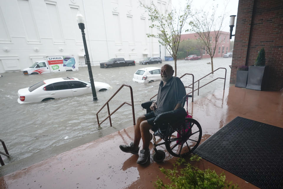 A man watches floodwaters, Wednesday, Sept. 16, 2020, in downtown Pensacola, Fla. Hurricane Sally made landfall Wednesday near Gulf Shores, Alabama, as a Category 2 storm, pushing a surge of ocean water onto the coast and dumping torrential rain that forecasters said would cause dangerous flooding from the Florida Panhandle to Mississippi and well inland in the days ahead. (AP Photo/Gerald Herbert)