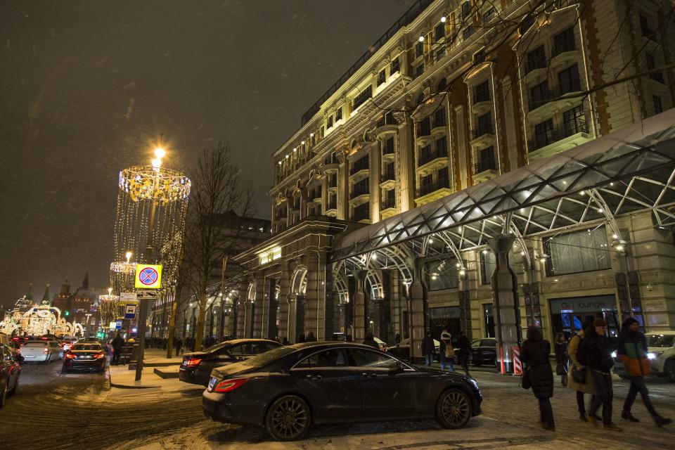 In this photo taken on Monday, Feb. 13, 2017, people walk past the Ritz-Carlton hotel, right, with Red Square behind in the background left, in Moscow, Russia. Despite saying he wanted to build a Trump tower in Russia, Donald Trump, who stayed at the Ritz in 2013, never completed a deal in the country's booming _ but volatile _ real estate and hotel market. (AP Photo/Alexander Zemlianichenko)