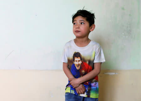 Murtaza Ahmadi, 7, an Afghan Lionel Messi fan, stands in his house in Kabul, Afghanistan December 8, 2018. REUTERS/Mohammad Ismail
