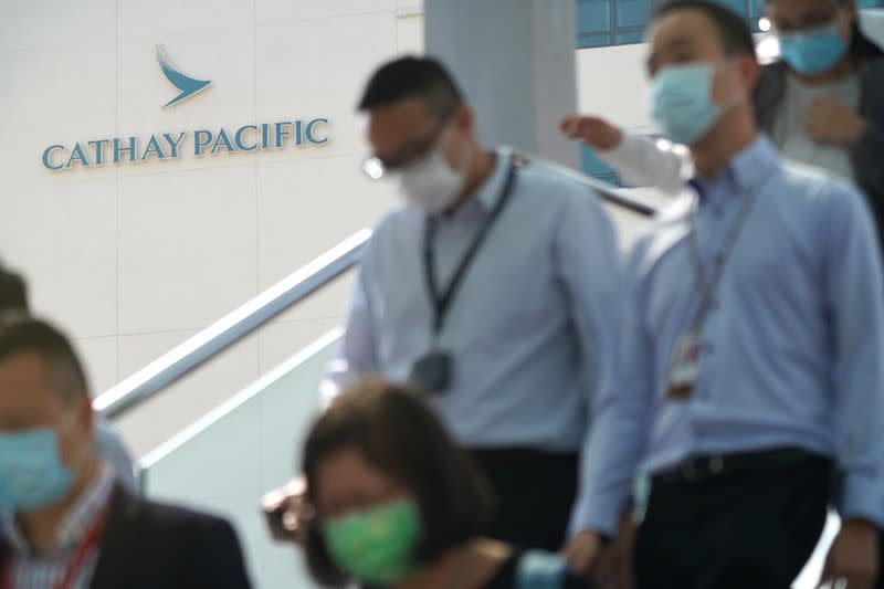 People wearing face masks following the coronavirus disease (COVID-19) outbreak, walk out of Cathay City, the headquarters of Cathay Pacific
