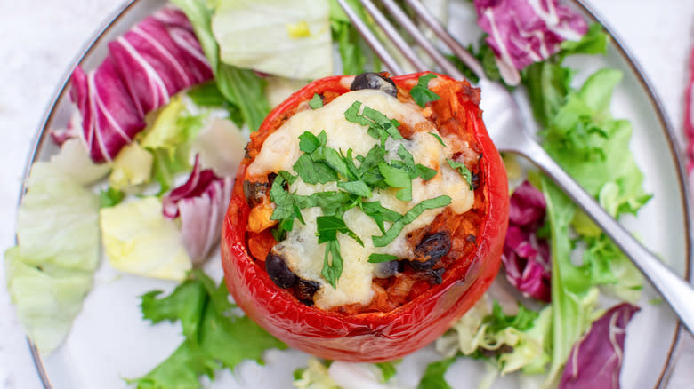 cheesy stuffed bell pepper on plate with salad