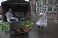 Kashmiri vegetable vendors wait for customers during lockdown inside the wholesale market in Srinagar, Indian controlled Kashmir, Friday, April 17, 2020. Indian Prime Minister Narendra Modi on Tuesday extended the world's largest coronavirus lockdown to head off the epidemic's peak, with officials racing to make up for lost time. (AP Photo/ Dar Yasin)