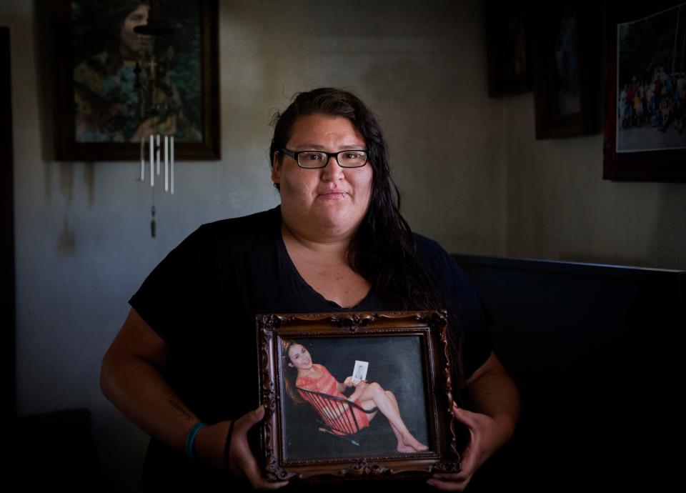 In this July 13, 2018, file photo, Kimberly Loring stands in her grandmother's home in Browning, Mont., holding a photo of her sister, Ashley HeavyRunner Loring, who went missing on the Blackfeet Indian Reservation in 2017.