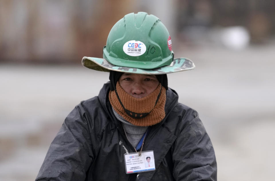 A Vietnamese worker rides a bicycle on his way to start his working day at the first Chinese car tire factory in Europe near the northern Serbian town of Zrenjanin, 50 kilometers north of Belgrade, Serbia, Thursday, Nov. 18, 2021. Reports have emerged in Serbia of prison-like conditions for some 500 of them at the construction site in north of the country where China's Shandong Linglong Tire Co is building the huge factory. Populist-run Serbia is a key spot for China's expansion and investment policies in Europe and Chinese companies have kept a tight lid on their projects in the country amid reports of disrespect of the Balkan nation's anti-pollution laws and labor regulations. (AP Photo/Darko Vojinovic)