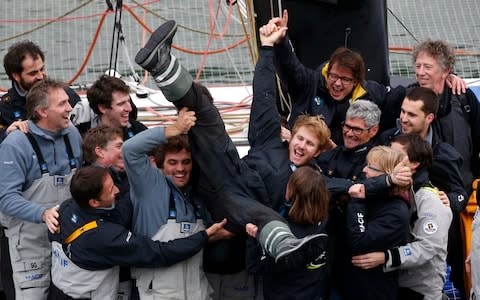 French skipper Francois Gabart celebrates his world record with his team, in the Brest harbor, western France, - Credit: Thibaut Camus/AP