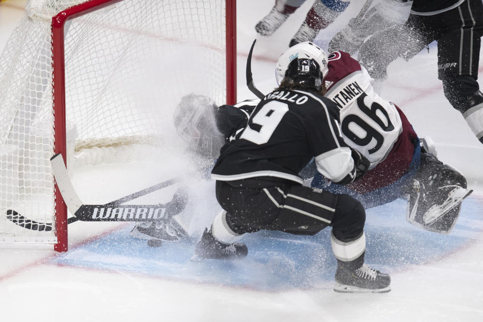 Los Angeles Kings goaltender Calvin Petersen, left, dives to stop the puck rolling behind him during the second period of the team's NHL hockey game against the Colorado Avalanche on Tuesday, Jan. 19, 2021, in Los Angeles. (AP Photo/Kyusung Gong)