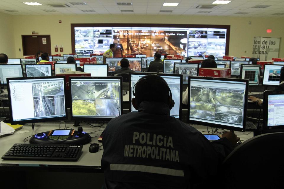 TO GO WITH AFP STORY BY HECTOR VELASCO Picture taken at the Integrated Security Service ECU 911 on November 9, 2013 in Quito. The controversial video surveillance system reached taxis and public buses and quintupled in the last two years  in Ecuador, service director Cesar Navas told AFP. AFP PHOTO/JUAN CEVALLOS        (Photo credit should read JUAN CEVALLOS/AFP/Getty Images)