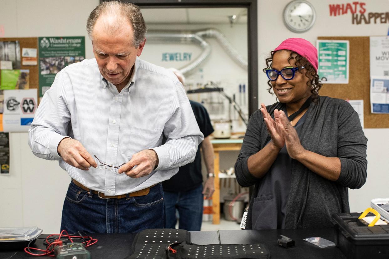 Mona Peacewalker, of Romulus, celebrates after volunteer fixer Jeff Campau successfully repaired a piece of infrared knee sleeve that was partially working during Fix-It Friday at Maker Works in Ann Arbor on Friday, April 19, 2024.