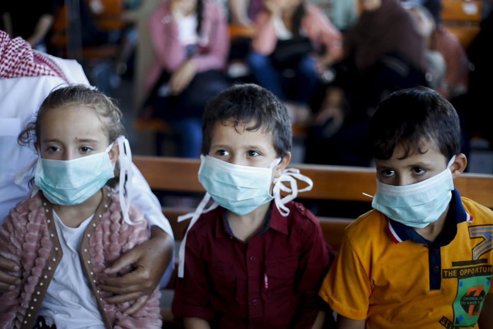 GAZA, PALESTINE - 2020/08/11: Palestinian children wearing protective masks, are seen seated as they wait to leave through the Rafah border crossing with Egypt. Egypt reopens the Rafah land crossing after months of closure due to the Coronavirus pandemic in the southern Gaza Strip. (Photo by Yousef Masoud/SOPA Images/LightRocket via Getty Images)