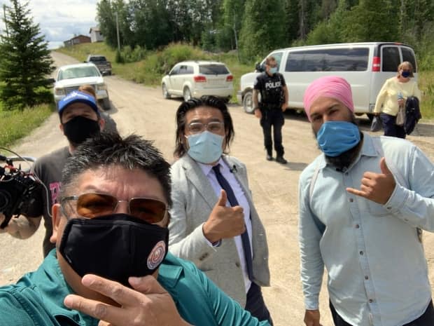 NDP Leader Jagmeet Singh, right, poses for a selfie with NDP MPP Sol Mamakwa, centre, and former Neskantaga chief Chris Moonias, front, during a visit to the First Nation. (Submitted by Chris Moonias - image credit)