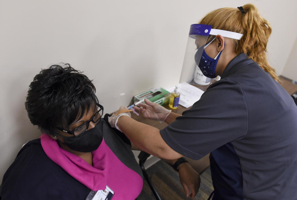 Reading, PA - January 6: CMA Mia Alicea uses a syringe to administer a dose of the Moderna COVID-19 vaccine to Mary Kargbo, the President and CEO of the Berks Community Health Center. At the Berks Community Health Center in Reading Wednesday afternoon January 6, 2021, where they were administering the Moderna COVID-19 Vaccine to staff and other healthcare workers. (Photo by Ben Hasty/MediaNews Group/Reading Eagle via Getty Images)