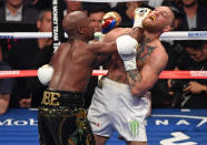 <p>(L-R) Floyd Mayweather Jr. throws a punch at Conor McGregor during their super welterweight boxing match on August 26, 2017 at T-Mobile Arena in Las Vegas, Nevada. </p>