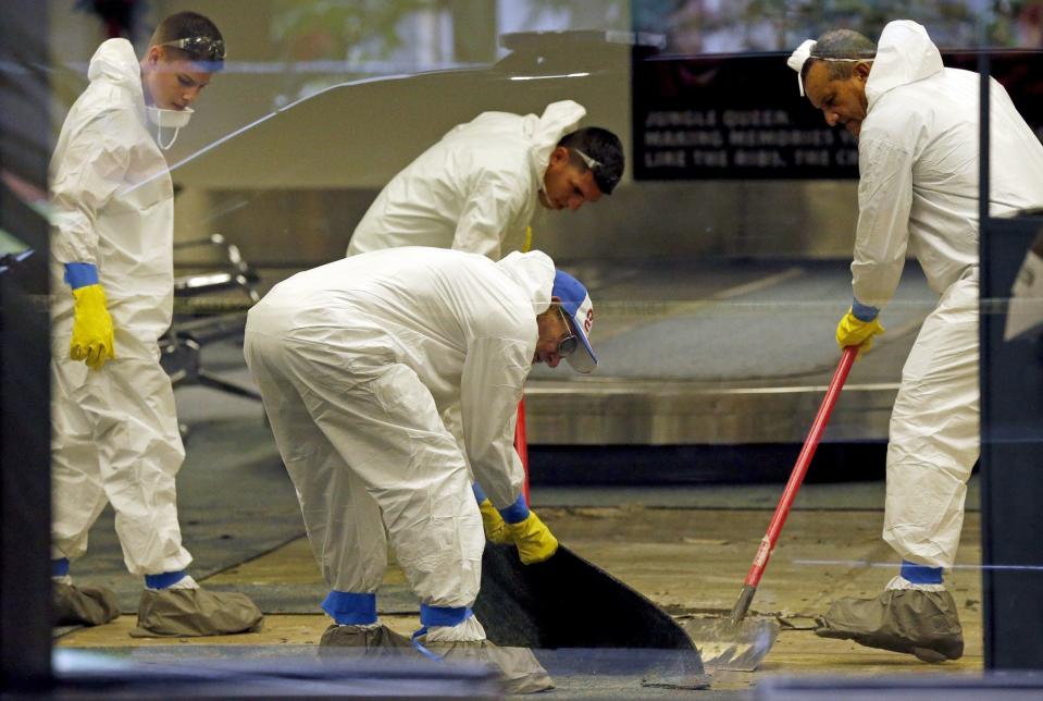 A hazmat crew cleans up baggage claim Terminal Two on Saturday, Jan. 7, 2017 at Fort Lauderdale-Hollywood International Airport Terminal the day after multiple people were shot on Friday.(Al Diaz/Miami Herald via AP)