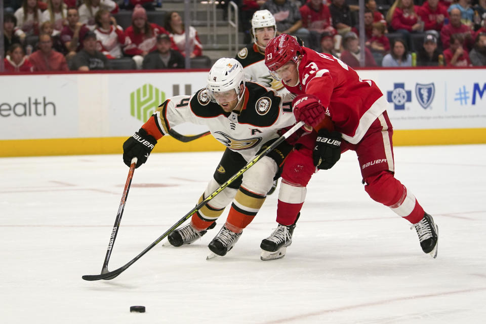 Anaheim Ducks defenseman Cam Fowler (4) and Detroit Red Wings left wing Lucas Raymond (23) battle for the puck in the second period of an NHL hockey game Sunday, Oct. 23, 2022, in Detroit. (AP Photo/Paul Sancya)