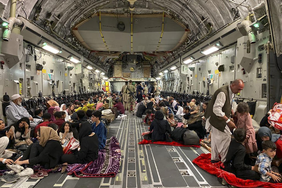 TOPSHOT - Afghan people sit inside a U S military aircraft to leave Afghanistan, at the military airport in Kabul on August 19, 2021 after Taliban's military takeover of Afghanistan. (Photo by Shakib RAHMANI / AFP) (Photo by SHAKIB RAHMANI/AFP via Getty Images)