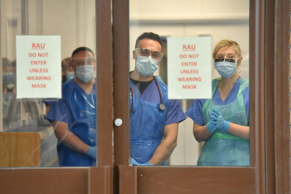 Medical staff wearing personal protective equipment (PPE) wait to receive coronavirus patients at the door of the Respiratory Assessment Unit at the Morriston Hospital in Swansea, as the health services prepare their response to the coronavirus outbreak.