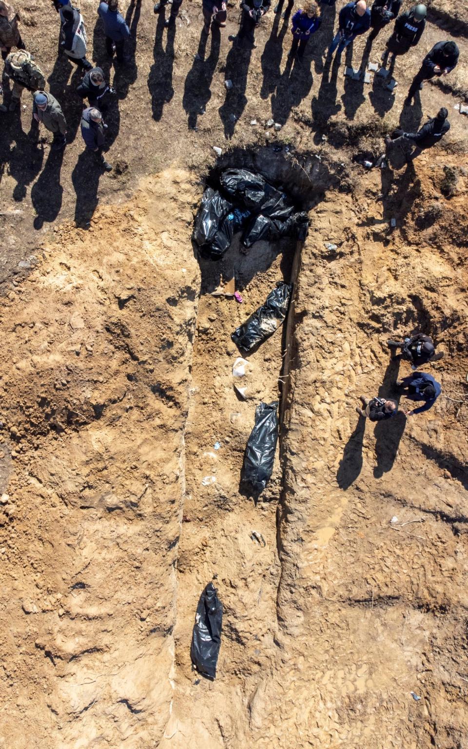An aerial view shows bodies wrapped in plastic in a mass grave in the Bucha area - Paul Grover for the Telegraph