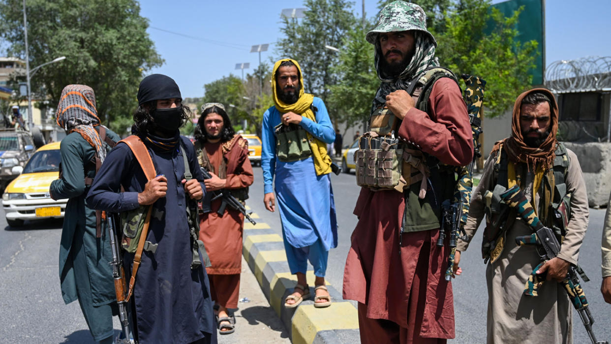 Taliban fighters stand guard along a street near the Zanbaq Square in Kabul on Monday.