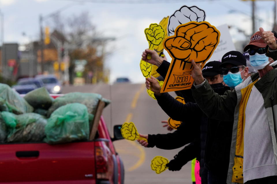 Canadian Union of Public Employees (CUPE) workers hold signs along the side of the Champlain Street Plaza during a strike, in Moncton, New Brunswick, Canada, November 1, 2021. REUTERS/John Morris