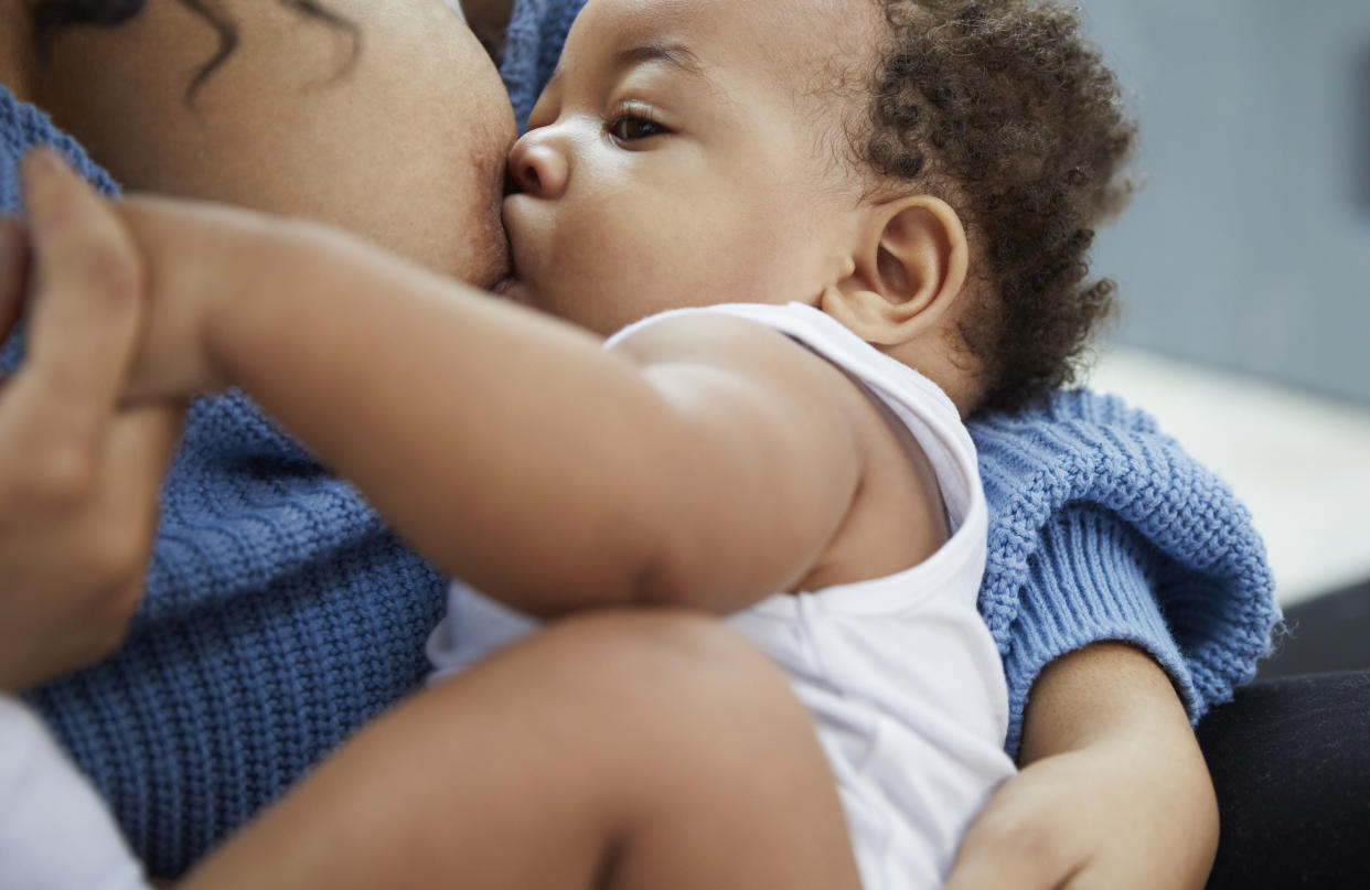A Black woman breastfeeds her child