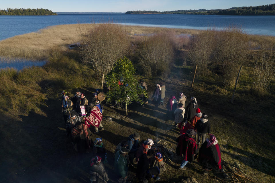 Community members circle a rewue, or ritual altar, while participating in celebrations of We Tripantu, the Mapuche new year, in the Corayen community of Los Rios, southern Chile, on Tuesday, June 21, 2022. For the Mapuche people, the rewue serves as a ladder between Earth and the spiritual world. (AP Photo/Rodrigo Abd)