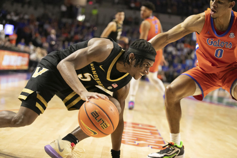 Vanderbilt guard Ezra Manjon (5) drives on Florida guard Zyon Pullin (0) during the first half of an NCAA college basketball game Saturday, Feb. 24, 2024, in Gainesville, Fla. (AP Photo/Alan Youngblood)