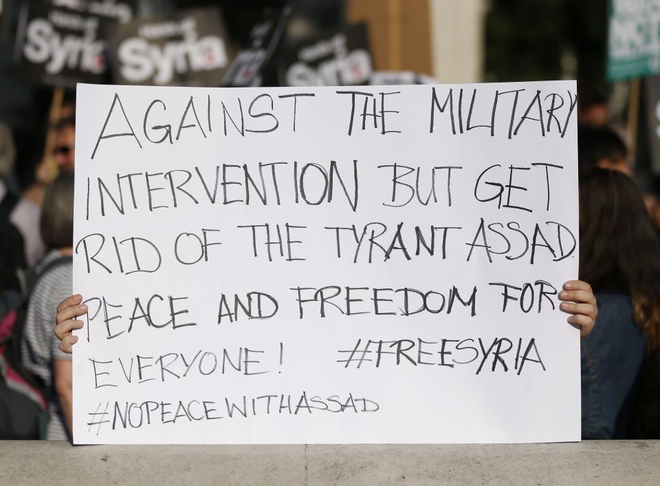 An activist holds a sign during an event organised by Stop the War Coalition to protest against potential UK involvement in the Syrian conflict in Whitehall, London.