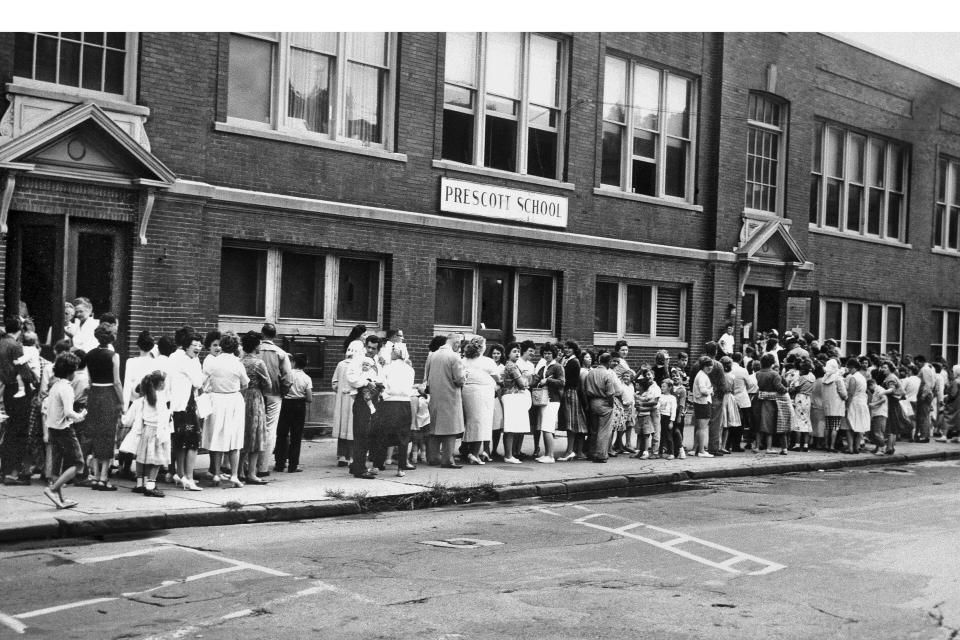 FILE - Parents and their children wait in long lines outside a Syracuse school to receive the Sabin oral polio vaccine on Aug. 29, 1961. The Centers for Disease Control and Prevention said the polio virus was detected in wastewater samples collected in June 2022 from Rockland County outside New York City. An unvaccinated adult recently contracted the life-threatening disease, but health officials said Tuesday, Aug. 2, 2022, they have not identified additional cases. (AP Photo, File)