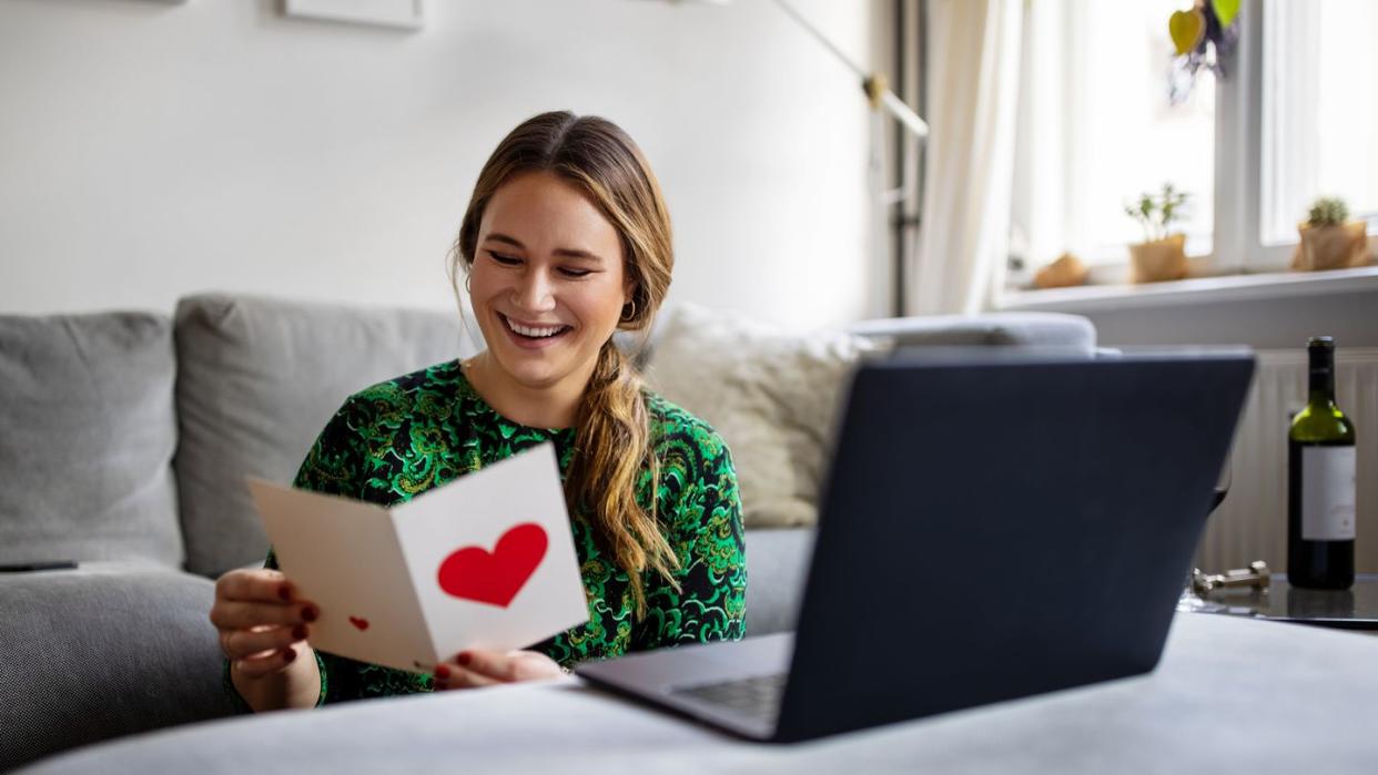 woman reading a greeting card during a video call