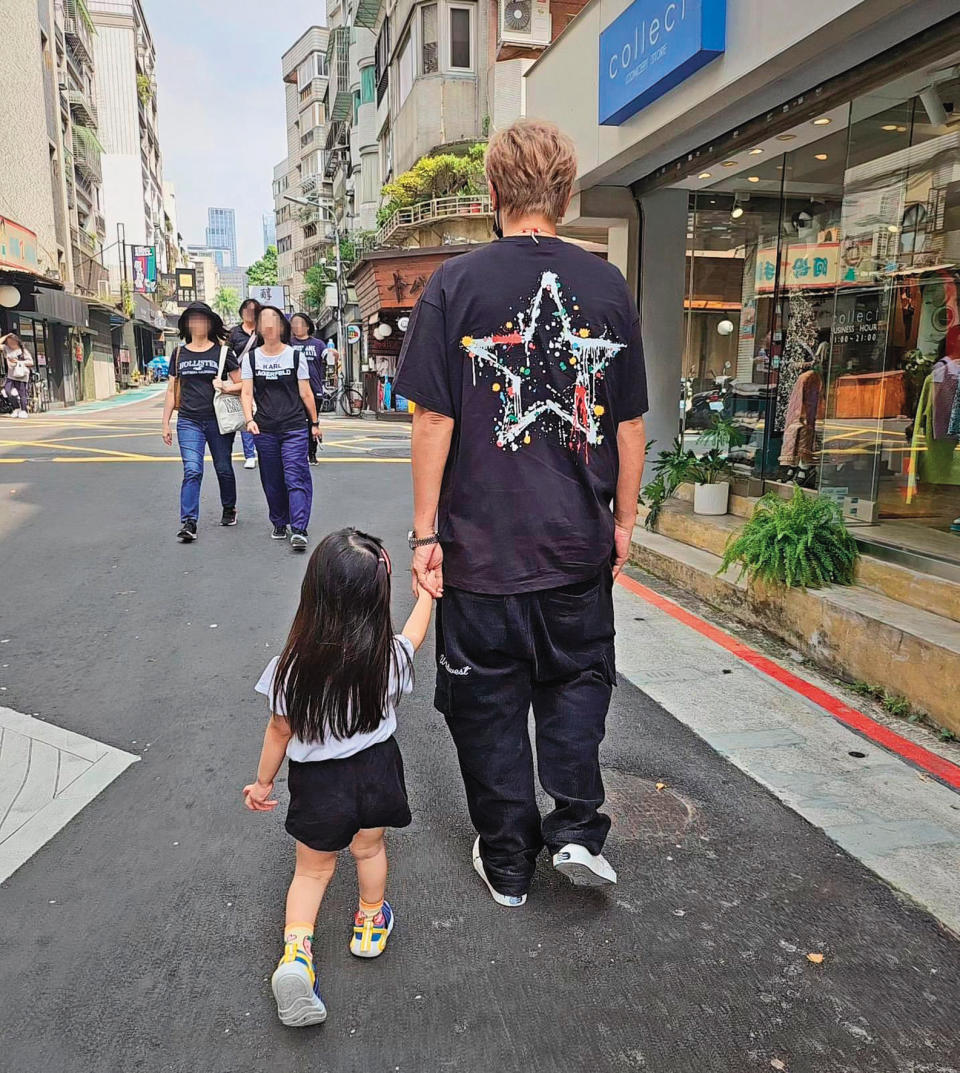 小豬曾牽著乾女兒的手，在自己的台北東區潮牌店附近散步。（翻攝自小霜IG）
