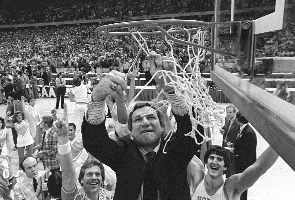 FILE - North Carolina basketball coach Dean Smith cuts the net as happy players and fans cheer after the Tar Heels defeated Georgetown for the NCAA college basketball championship in New Orleans, March 29,1982. (AP Photo/Pete Leabo, File)