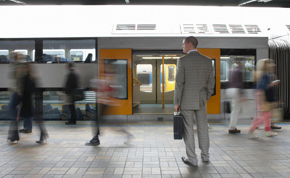 Australian employee stands outside of Sydney train. Image: Getty