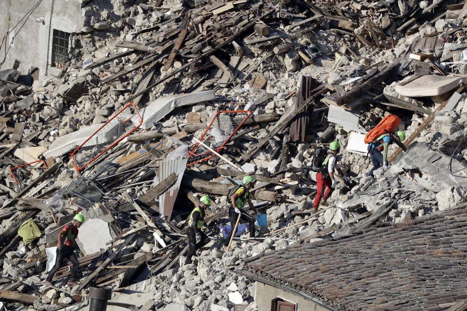 <p>Rescuers make their way through destroyed houses following an earthquake in Pescara Del Tronto, central Italy, Thursday, Aug. 25, 2016. (AP Photo/Gregorio Borgia) </p>