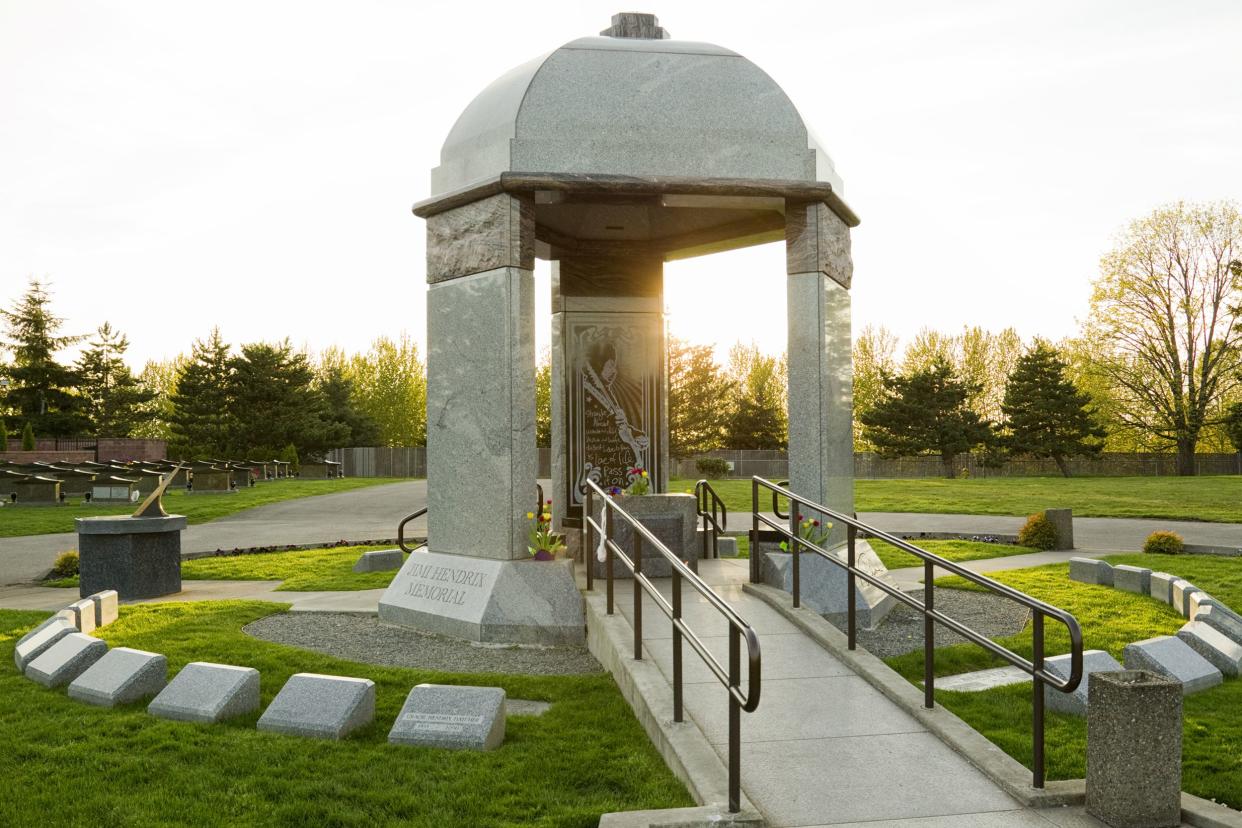 Jimi Hendrix's grave covered by a marble dome in Greenwood Memorial Park, Renton, Washington, surrounded by stones in a circle, with the sunlight dramatically coming through the dome on a sunny spring day