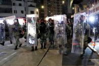 Riot police officers make their way along the street trying to disperse protesters gathering for a demonstration in Hong Kong