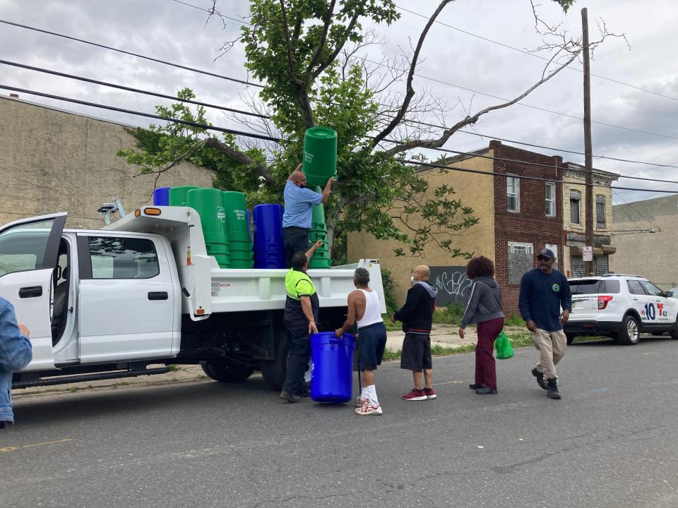 Employees with Camden's Department of Public Works hand out trash and recycling bins to residents in the city's Lanning Square neighborhood on Tuesday.