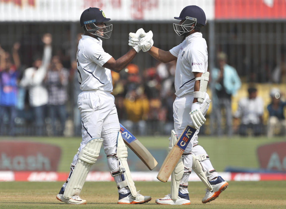 India's Mayank Agarwal, left, celebrates with batting partner Ajinkya Rahane after scoring a century during the second day of first cricket test match between India and Bangladesh in Indore, India, Friday, Nov. 15, 2019. (AP Photo/Aijaz Rahi)