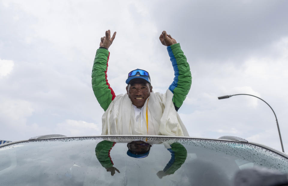 Renowned Sherpa mountain guide Kami Rita returning from Mount Everest after his record 30th successful ascent, waves after he arrives at the airport in Kathmandu, Nepal, Friday, May 24, 2024. (AP Photo/Niranjan Shrestha)