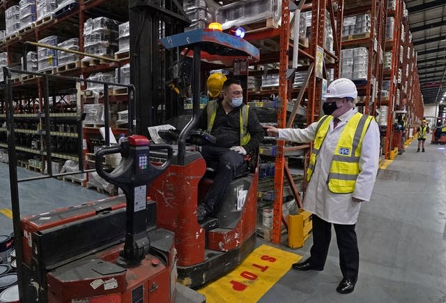 Boris Johnson, right, talks to a member of staff during  his visit to Johnstone’s Paints in Batley, West Yorkshire 