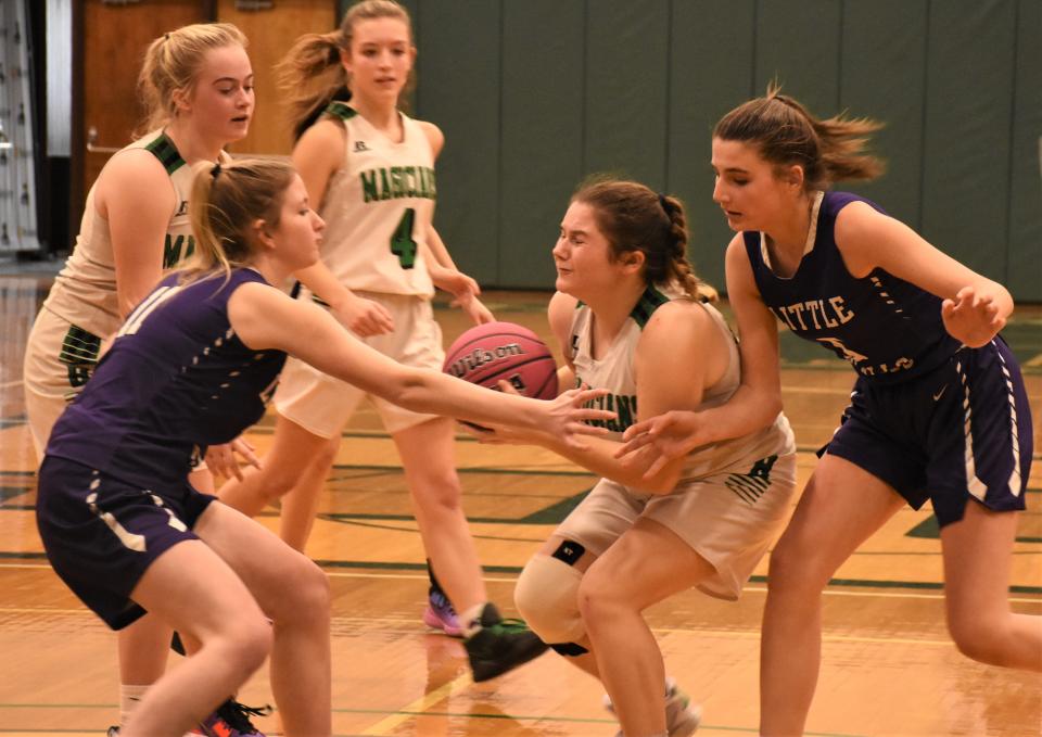 Herkimer Magician Bailey Bray gets caught between Little Falls Mounties Alyssa Eckler and Andylynn Podlas (from left) during the opening game of the Utica Biard of Officials for Women's Basketball Cancer Challenge at Herkimer College Sunday.