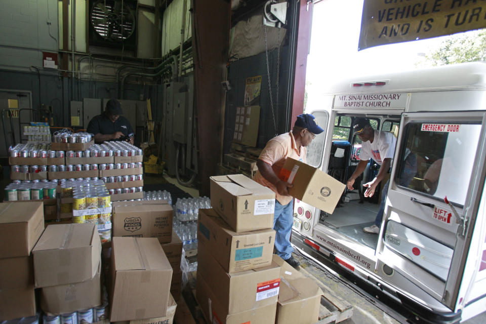 In this Monday, July 30, 2012 photo, volunteers load a church bus with food donated by the Second Harvest Food bank, in Orlando, Fla. The church will then distribute the food to those in need. In the past four years, food distribution to 500 pantries, shelters, and other relief agencies in the six-county area has jumped about 60 percent. In the last year alone, that amounted to 36 million pounds of food. (AP Photo/John Raoux)