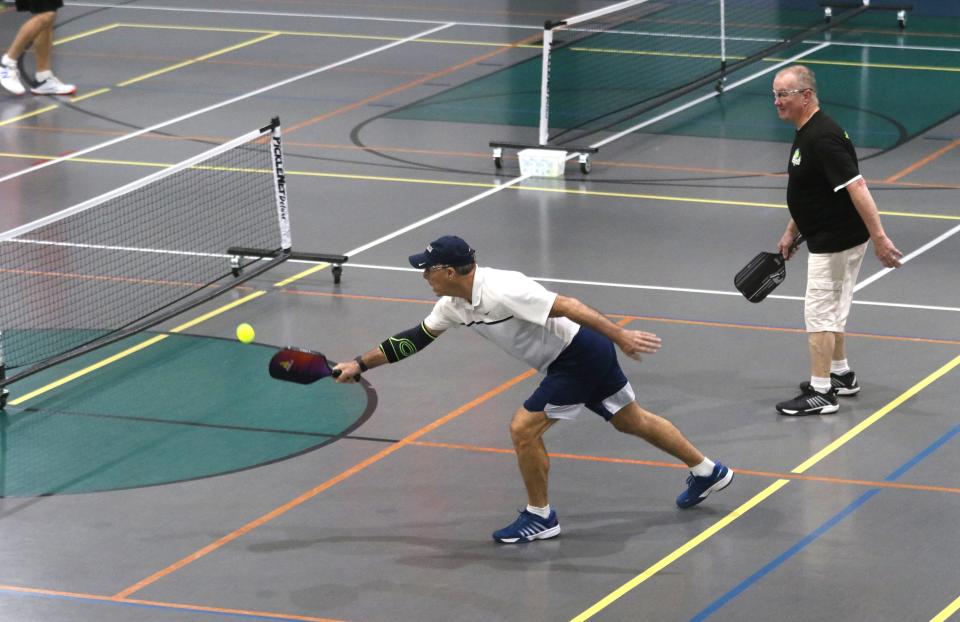 Rick Chambers watches as Eric Exley returns a shot during a pickleball match at Kids America recently.