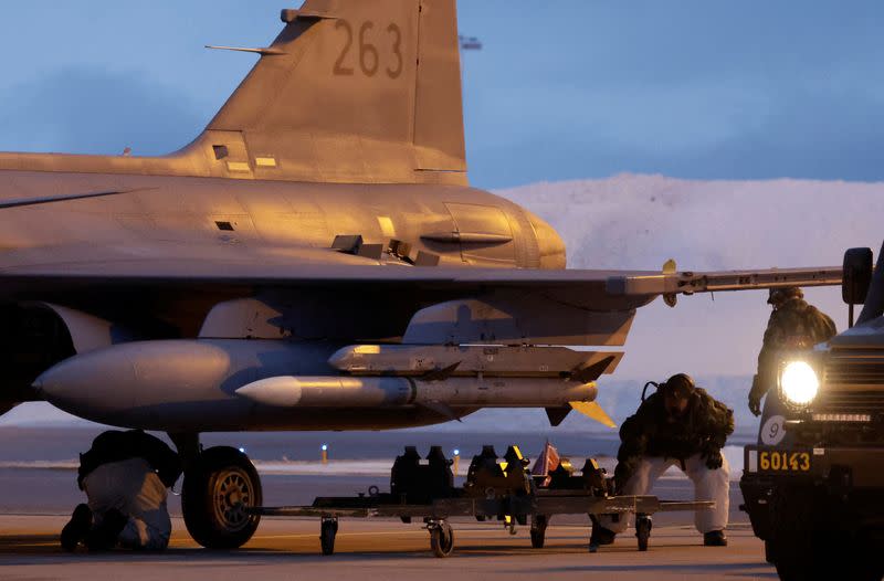 A Swedish air crew prepares a JAS Gripen fighter jet for takeoff at Kallax Air Base