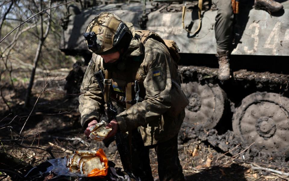 Vasilii, 34, a serviceman with Ukraine's 80th brigade, eats some Easter cake - KAI PFAFFENBACH/REUTERS