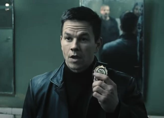 Mark Wahlberg as Max Payne holding his badge up