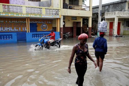 People walk in a flooded area after Hurricane Matthew in Les Cayes, Haiti, October 5, 2016. REUTERS/Andres Martinez Casares