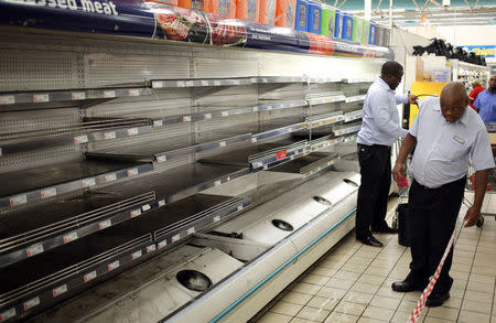 A worker looks at empty shelves after removing processed meat products at a Pick n Pay Store in Johannesburg, South Africa, March 5, 2018. REUTERS/Siphiwe Sibeko